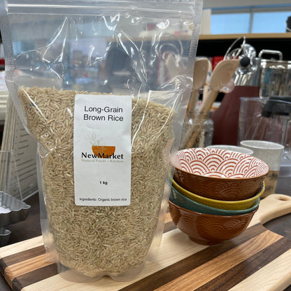 Resealable bag of long grain brown rice on a woo cutting board.