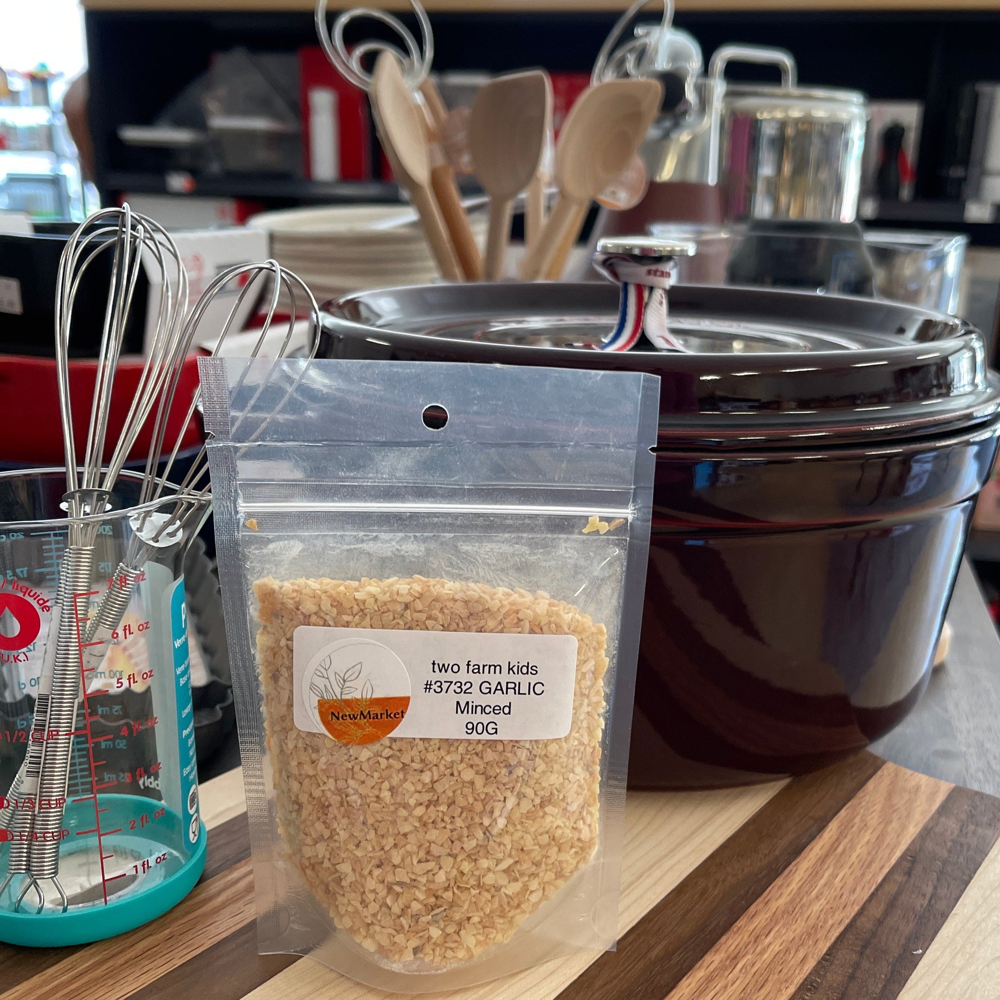 Package of minced garlic on a shelf with kitchen items in the background.
