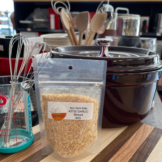 Package of minced garlic on a shelf with kitchen items in the background.