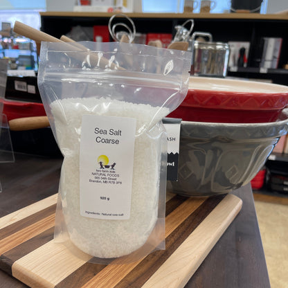 Coarse sea salt packaged product on a wooden cutting board with a blurred background