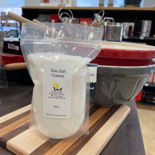Coarse sea salt packaged product on a wooden cutting board with a blurred background