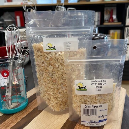 Packaged onion flakes in two sizes on a wooden surface