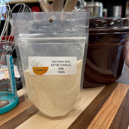 150g resealable plastic bag with garlic salt sitting on a wood cutting board.