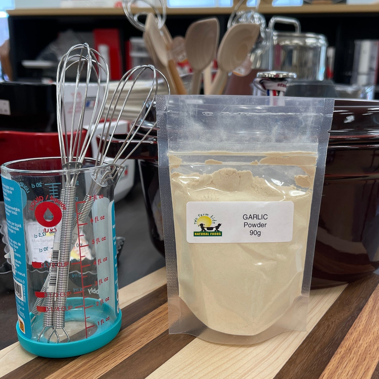 Bag of garlic powder with a label on a kitchen counter with various kitchen items.