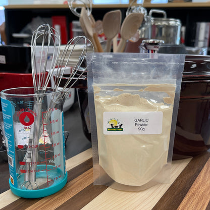 Bag of garlic powder with a label on a kitchen counter with various kitchen items.