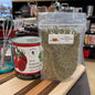 Packaged italian herbs on a kitchen counter with a jar of plum tomatoes and whisk in the background.