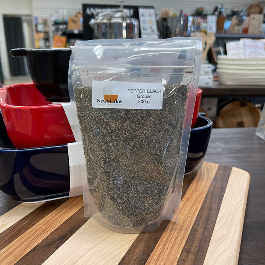 Packaged pepper on a shelf with wooden cutting boards in the background